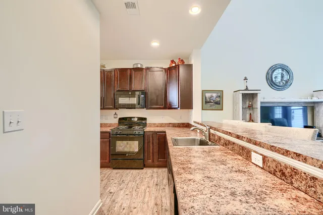 a kitchen with stainless steel appliances granite countertop a sink refrigerator and microwave