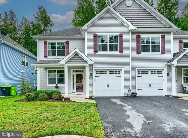 a view of a white house next to a yard and a yard