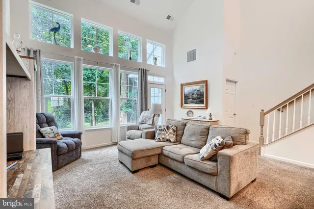 a living room with furniture a flat screen tv and a large window