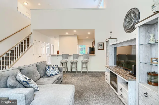 a living room with furniture a floor to ceiling window and a flat screen tv