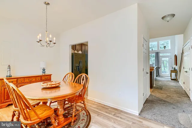 a dining room with furniture a chandelier and wooden floor