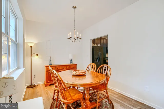 a view of a dining room with furniture a chandelier and wooden floor