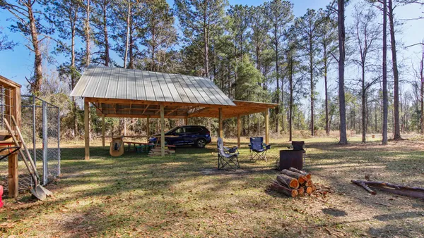 a view of a park with table and chairs under an umbrella