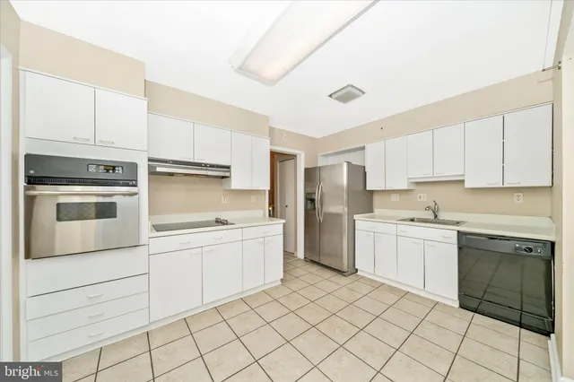 a kitchen with a stove sink and cabinets