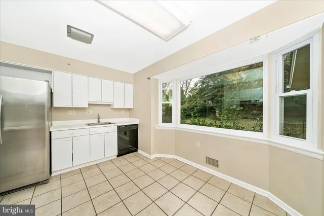 a kitchen with a refrigerator a sink and cabinets