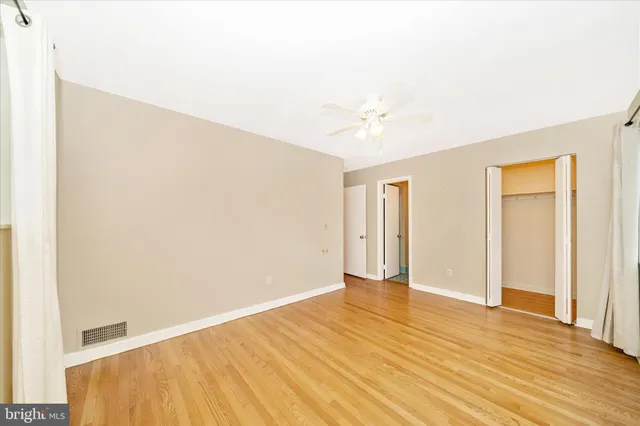 a view of an empty room with wooden floor