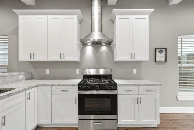 a kitchen with a sink stainless steel appliances a window and wooden floor