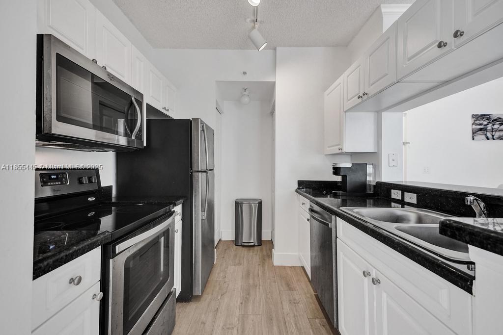 17100 North Bay Road, Unit 1511 Sunny Isles Beach, FL 33160 - Photo 11 of 71 a kitchen with stainless steel appliances a sink stove and refrigerator