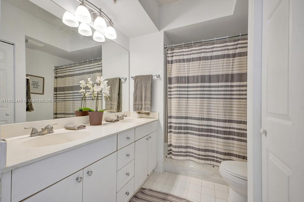 17100 North Bay Road, Unit 1511 Sunny Isles Beach, FL 33160 - Photo 13 of 71 a bathroom with a sink a large mirror and a shower