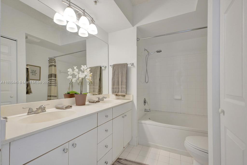 17100 North Bay Road, Unit 1511 Sunny Isles Beach, FL 33160 - Photo 14 of 71 a bathroom with a double vanity sink a large mirror and a bathtub