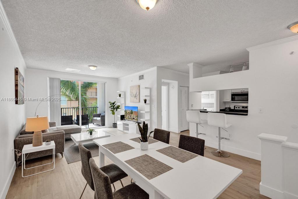17100 North Bay Road, Unit 1511 Sunny Isles Beach, FL 33160 - Photo 2 of 71 a living room with furniture a flat screen tv and a refrigerator