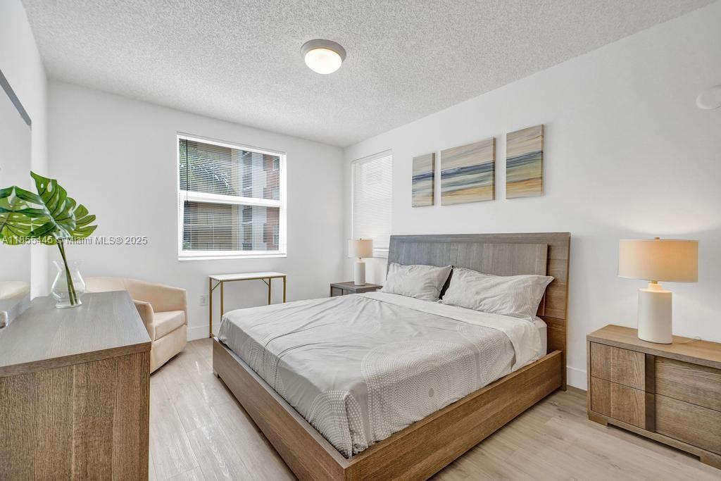 17100 North Bay Road, Unit 1511 Sunny Isles Beach, FL 33160 - Photo 5 of 71 a bedroom with a bed and wooden floor