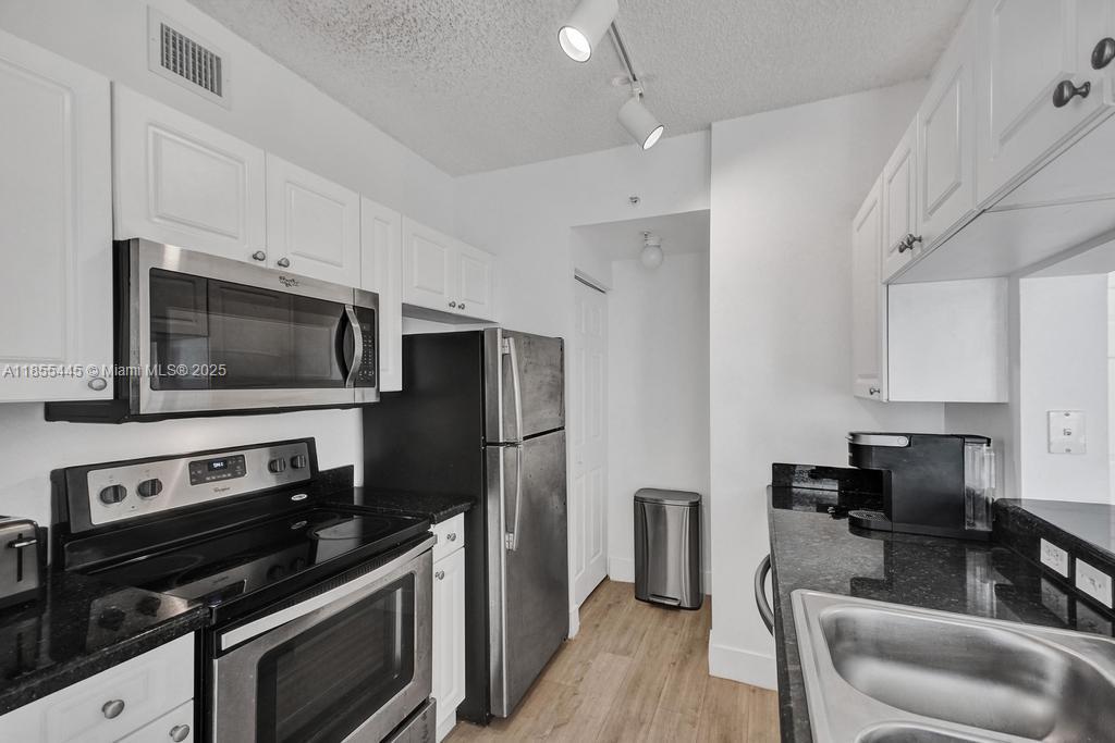 17100 North Bay Road, Unit 1511 Sunny Isles Beach, FL 33160 - Photo 60 of 71 a kitchen with stainless steel appliances a stove microwave and a refrigerator