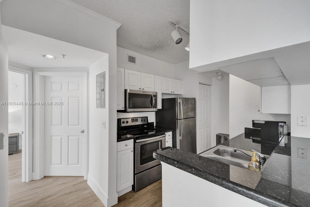 17100 North Bay Road, Unit 1511 Sunny Isles Beach, FL 33160 - Photo 61 of 71 a kitchen with stainless steel appliances granite countertop a stove a sink and a refrigerator