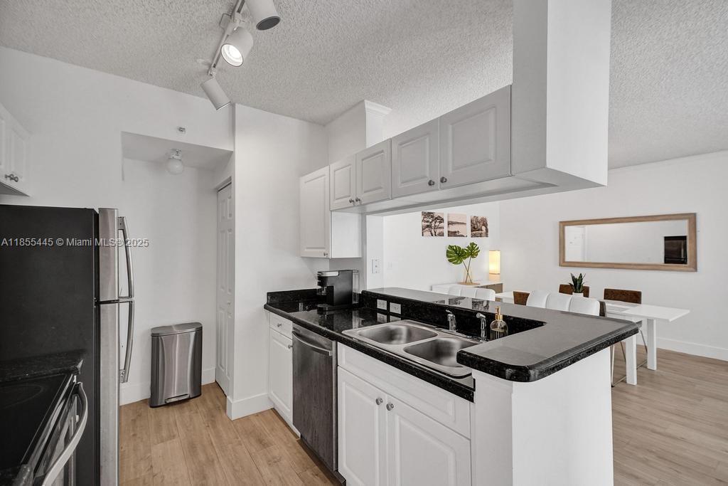 17100 North Bay Road, Unit 1511 Sunny Isles Beach, FL 33160 - Photo 10 of 71 a kitchen that has a sink stainless steel appliances a counter space and a window