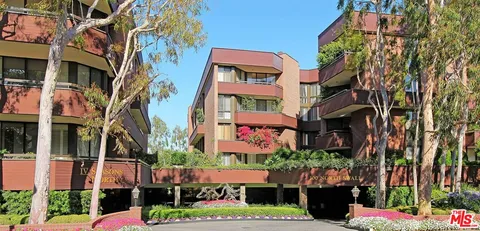 a front view of multi story residential apartment building with yard