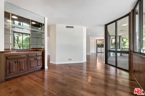 a view of a open entryway with wooden floor and a cabinet