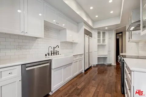 a kitchen with white cabinets and white appliances