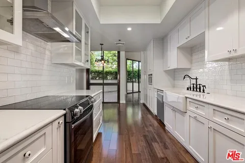 a kitchen with granite countertop a sink a counter space and stainless steel appliances