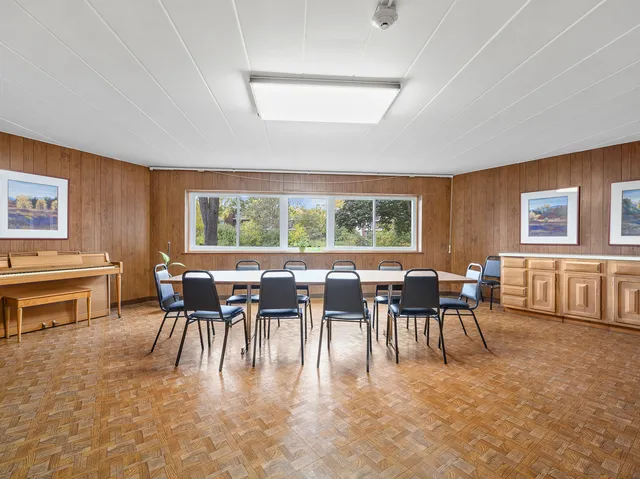 a dining room with furniture a flat screen tv and a window