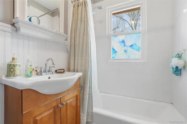 a bathroom with a sink mirror and a bathtub