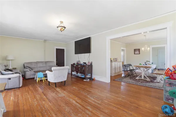 a living room with furniture a fireplace and a dining table with wooden floor