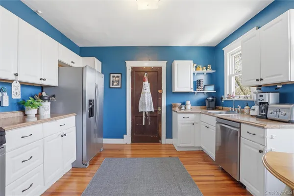 a kitchen with white cabinets and refrigerator
