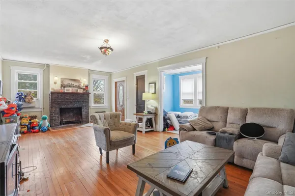a livingroom with furniture wooden floor a fireplace and a window