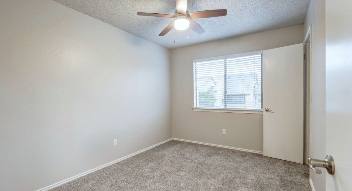 1338 Christopher Avenue, Unit 1212 Round Rock, TX 78681 - Photo 12 of 13 an empty room with a window and a fan