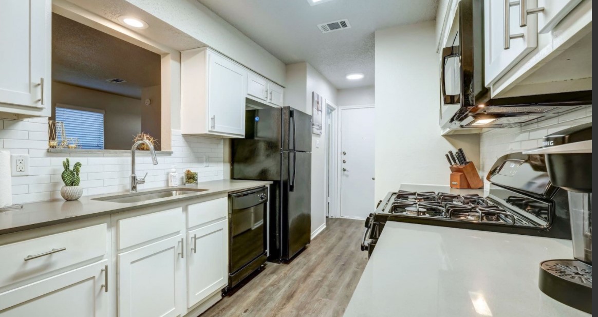 1338 Christopher Avenue, Unit 1212 Round Rock, TX 78681 - Photo 8 of 13 a kitchen with stainless steel appliances kitchen island granite countertop a sink stove and refrigerator