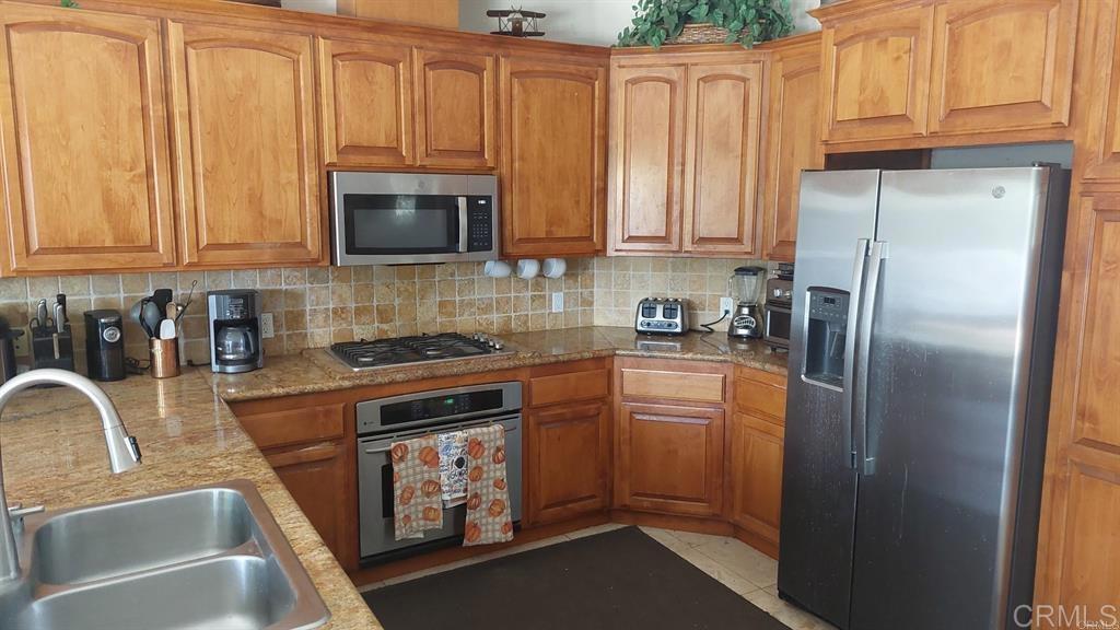 2399 Paige Circle Fallbrook, CA 92028 - Photo 12 of 18 a kitchen with stainless steel appliances granite countertop a refrigerator sink and cabinets