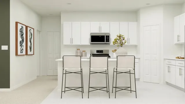 a white kitchen with stainless steel appliances and white cabinets