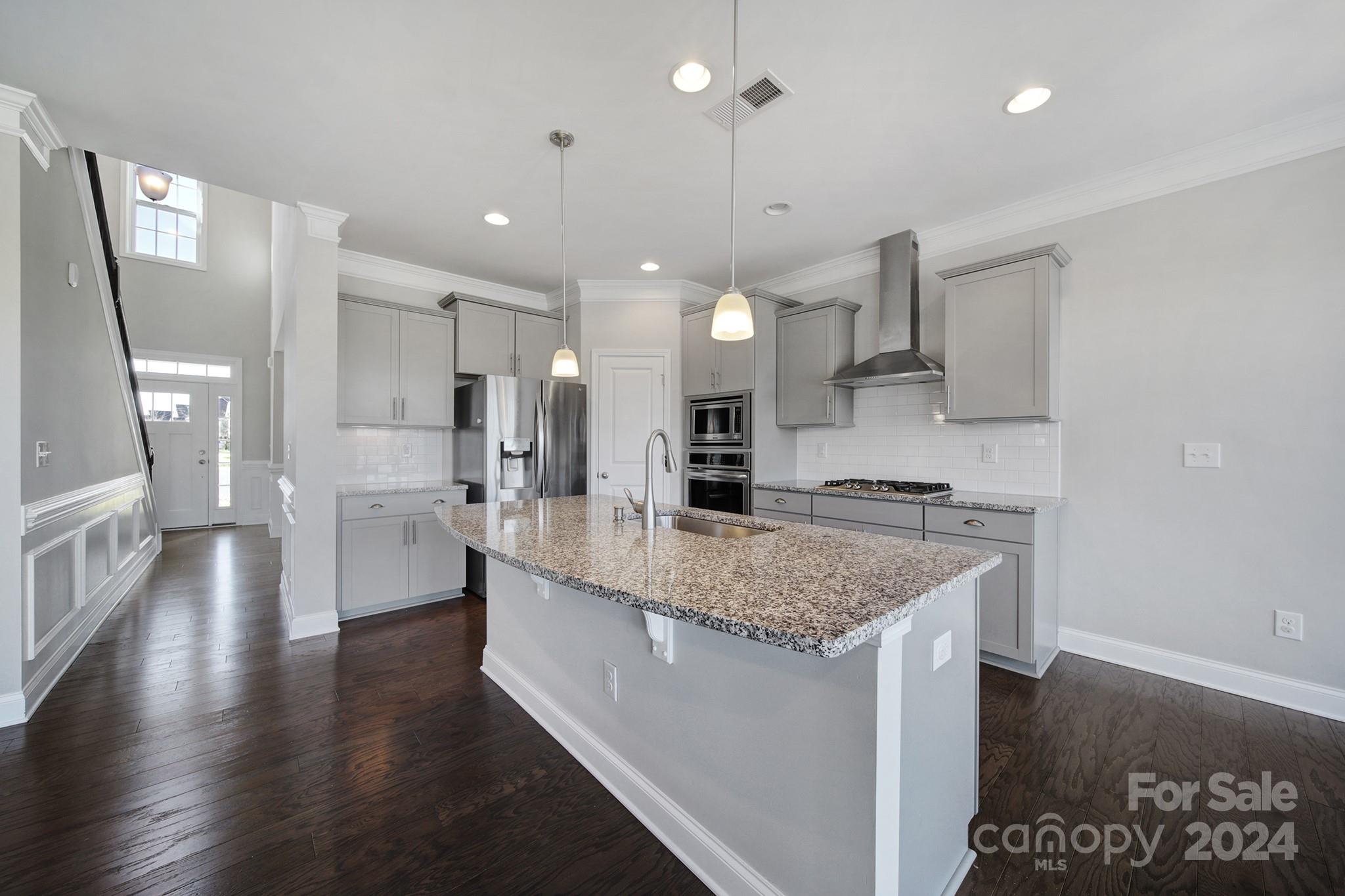 9518 Inverness Bay Road Charlotte, NC 28278 - Photo 11 of 42 a large kitchen with stainless steel appliances kitchen island a large counter top and a wooden floors