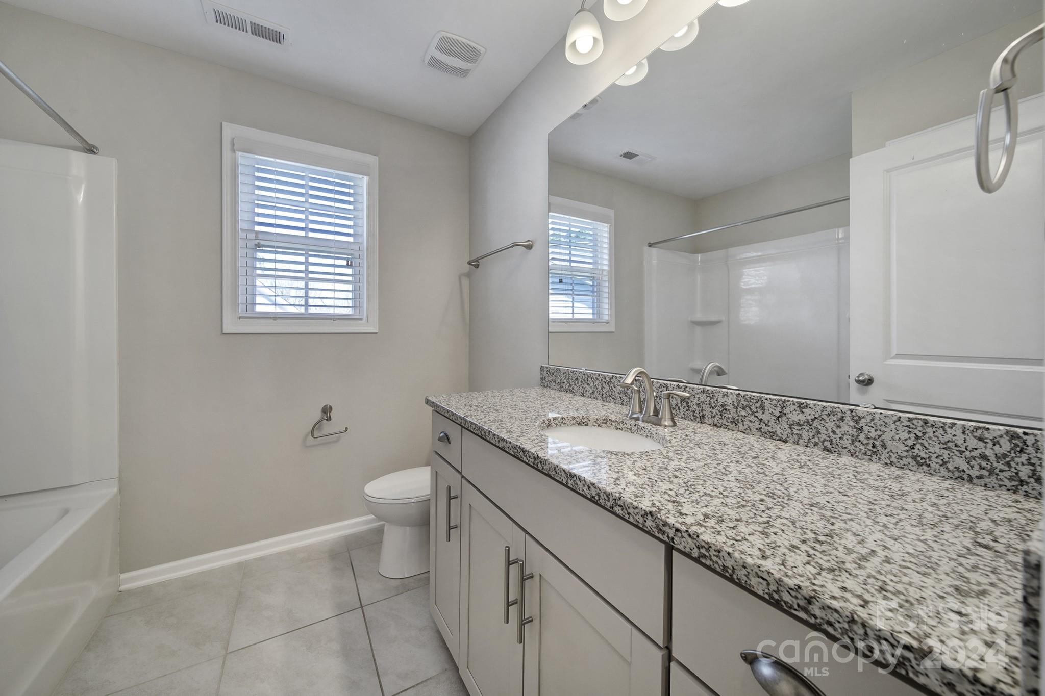 9518 Inverness Bay Road Charlotte, NC 28278 - Photo 23 of 42 a bathroom with a granite countertop sink a toilet and a window