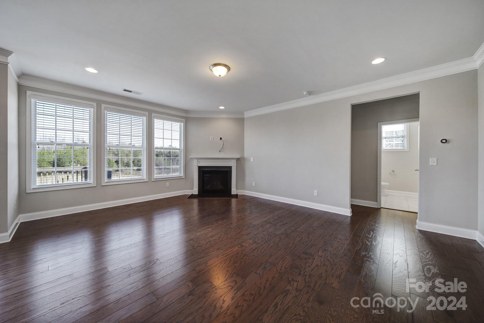 9518 Inverness Bay Road Charlotte, NC 28278 - Photo 6 of 42 a view of empty room with wooden floor and fireplace