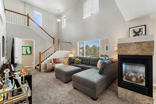 a living room with furniture a fireplace and a large window