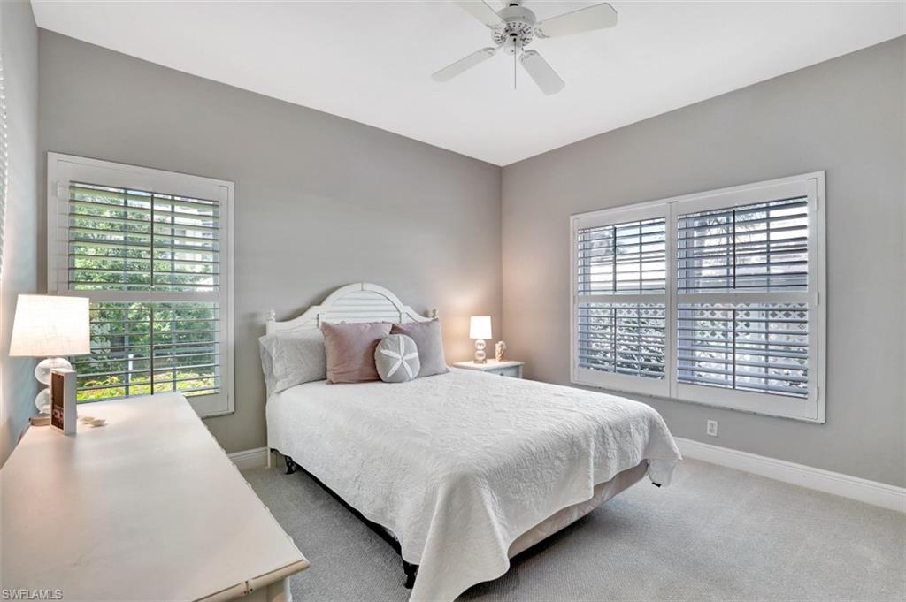 5897 Chanteclair Drive, Unit 314 Naples, FL 34108 - Photo 11 of 20 a bedroom with a large bed and a chandelier