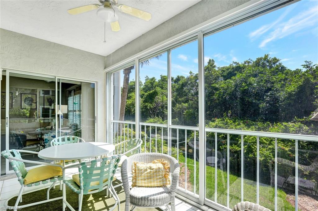 5897 Chanteclair Drive, Unit 314 Naples, FL 34108 - Photo 16 of 20 a view of a balcony with chair and glass door