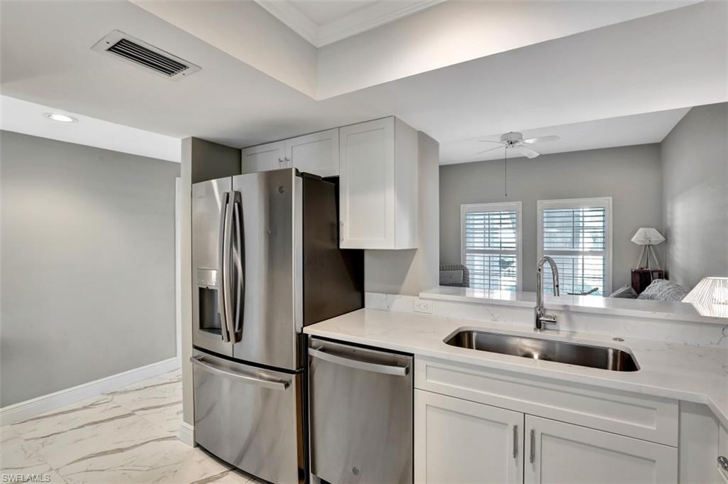 5897 Chanteclair Drive, Unit 314 Naples, FL 34108 - Photo 5 of 20 a kitchen with stainless steel appliances a refrigerator sink and cabinets