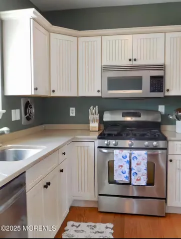 a kitchen with stainless steel appliances granite countertop a sink stove and microwave