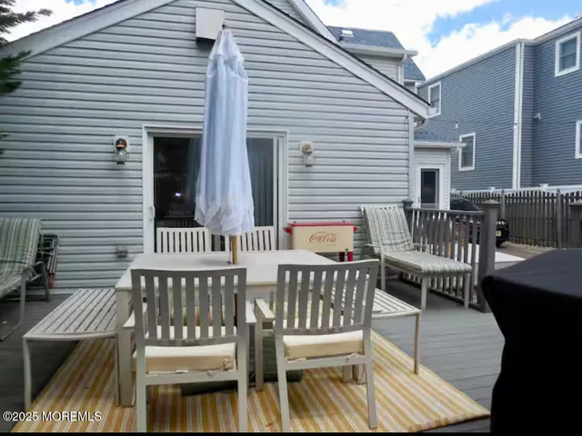 a view of a patio with table and chairs with wooden floor and fence