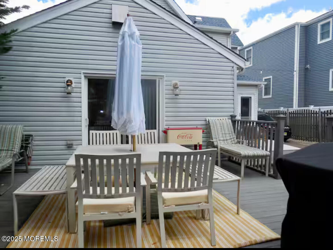 24 Philadelphia Avenue Lavallette, NJ 08735 - Photo 31 of 41 a view of a roof deck with table and chairs with wooden floor and fence