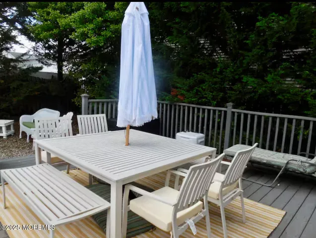 a view of a patio with table and chairs with wooden floor and fence