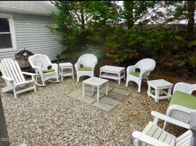 a view of backyard with seating space and trees