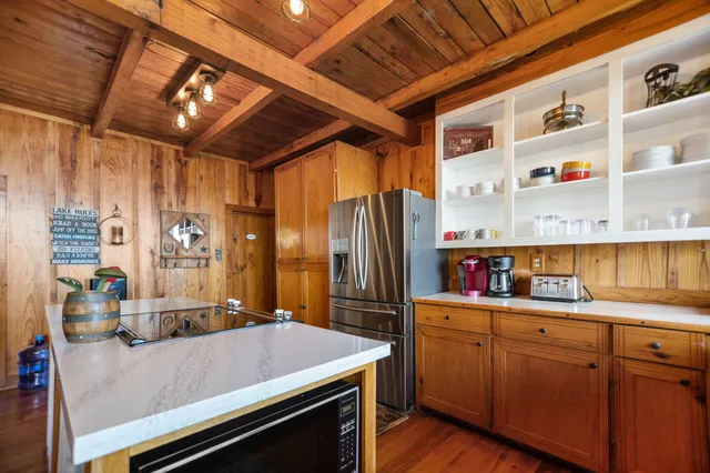 a kitchen with a refrigerator a sink and wooden floor