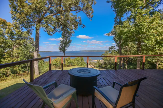 a patio with wooden floor a yard a table and chairs