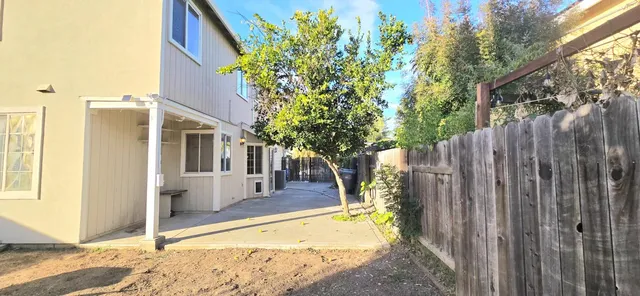a view of a house with backyard and tree