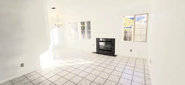 a view of an empty room with window and cabinet