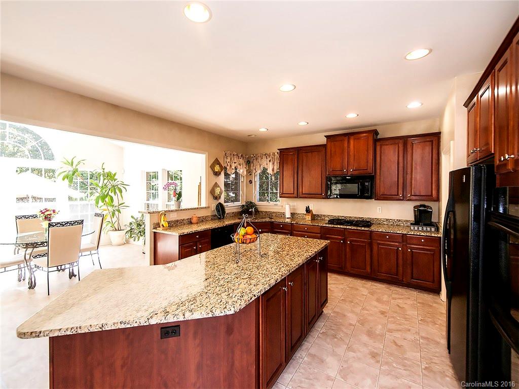 748 Drew Avenue Fort Mill, SC 29708 - Photo 7 of 23 a large kitchen with kitchen island granite countertop a large counter top couches and stainless steel appliances