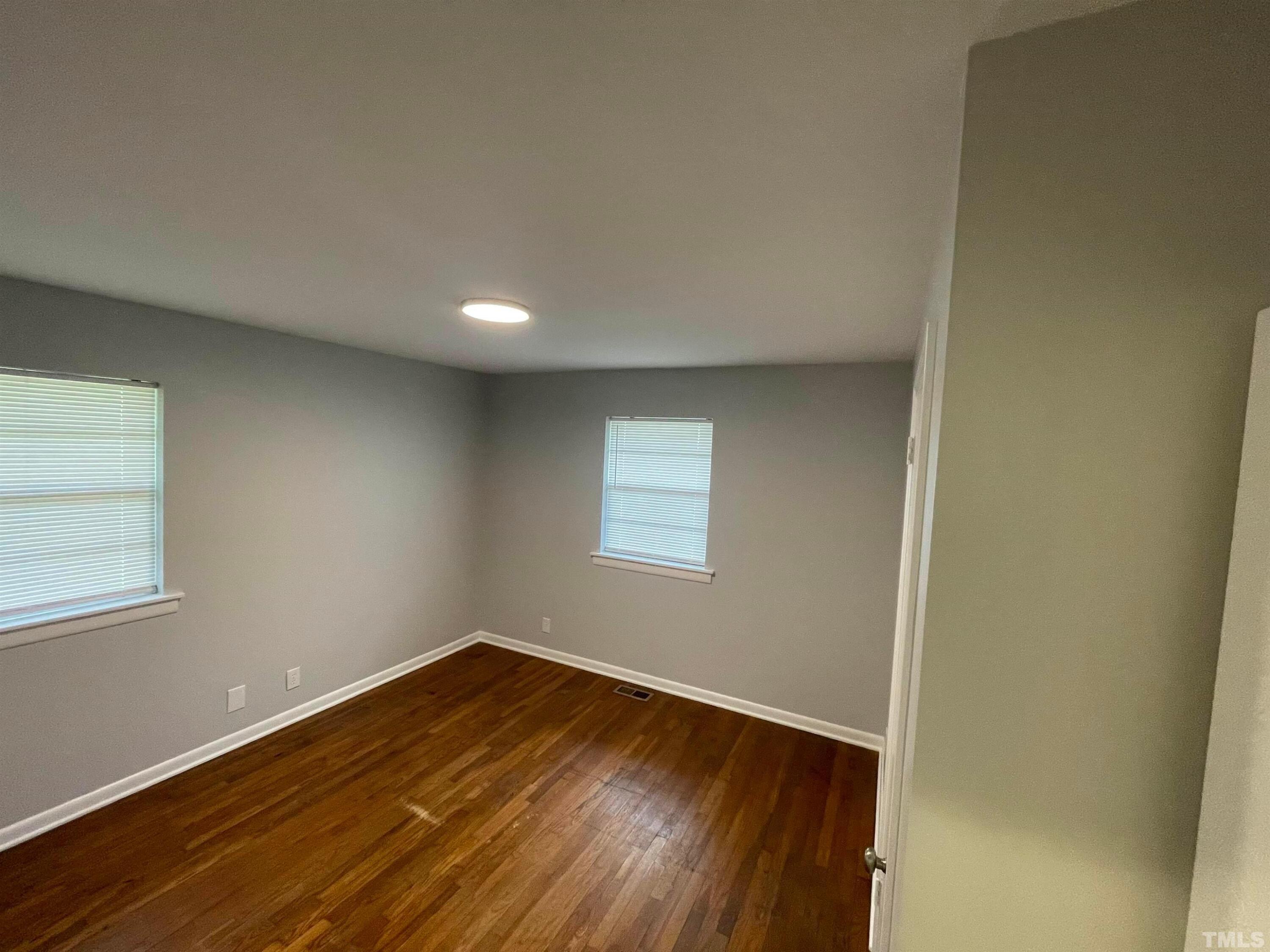 334 Clark Street, Unit A Durham, NC 27701 - Photo 14 of 16 an empty room with wooden floor and windows